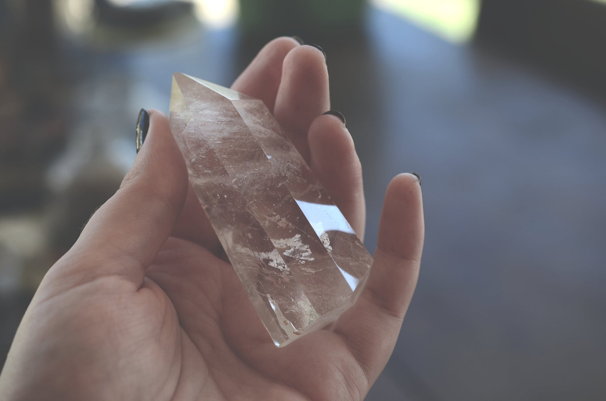 A female hand holds a gemstone tip.