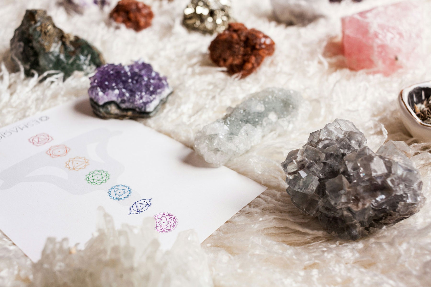 raw gemstones next to a card with the chakra symbols.