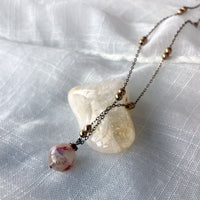 A close-up of a gold plated necklace with a 10mm Citrine bead on a delicate chain with 3mm Ball and 1mm Curb Chain.