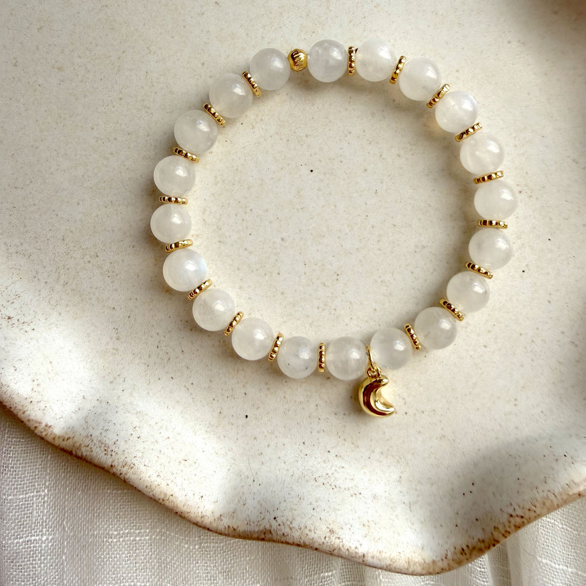 Lunar Moonstone Bracelet featuring genuine Moonstone gemstones, gold-plated spacer beads, and a crescent moon charm, handcrafted for everyday wear.