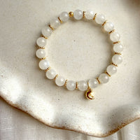 Lunar Moonstone Bracelet featuring genuine Moonstone gemstones, gold-plated spacer beads, and a crescent moon charm, handcrafted for everyday wear.
