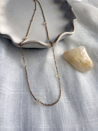 Modern minimalist jewelry piece featuring citrine gemstones for energy and joy, displayed with natural light for an elegant look.