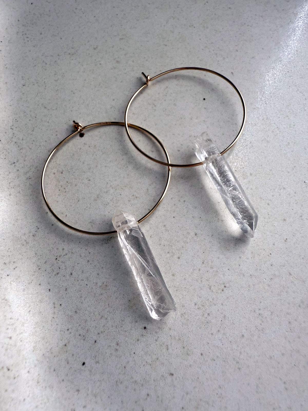 Pair of Purity Earrings featuring clear quartz point gemstones on gold-filled hoops, elegant handmade hoop earrings for everyday wear.