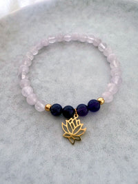 “See Truth Within” chakra bracelet by Moksha Jewelry, handcrafted with lavender amethyst and deep amethyst beads, accented with gold details and a lotus charm, displayed on a soft stone background—designed to activate the third eye chakra and promote intuition, clarity, and spiritual insight.