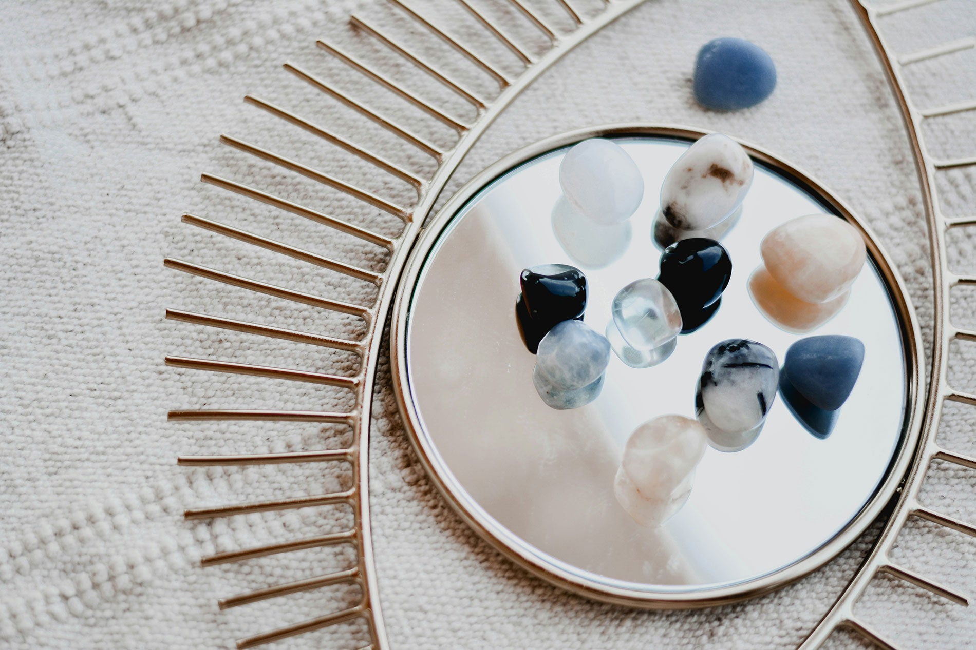 A variation of different gemstones on a mirror in form of an evil eye.